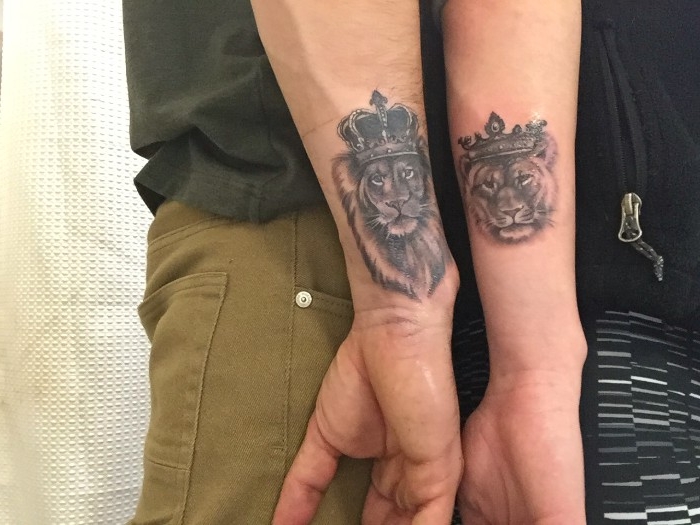 male and female lion, both wearing crowns, matching couple tattoos, done with black ink, on the lower part of two arms