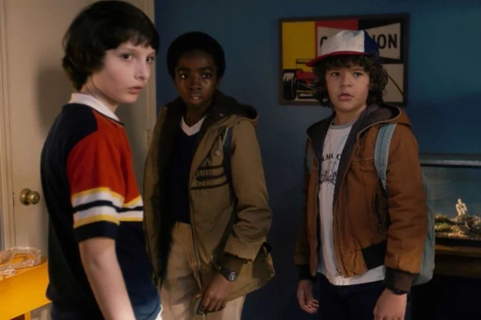 caleb mclaughlin and gaten matarazzo and finn wolfhard, dressed in retro clothes, for the series stranger things, 80s costumes men and kids, dress code nostalgia