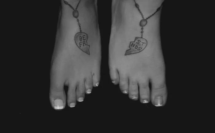 matching bestfriend tattoos, two halves of a heart-shaped friendship pendant, tattooed on two feet, standing next to each other