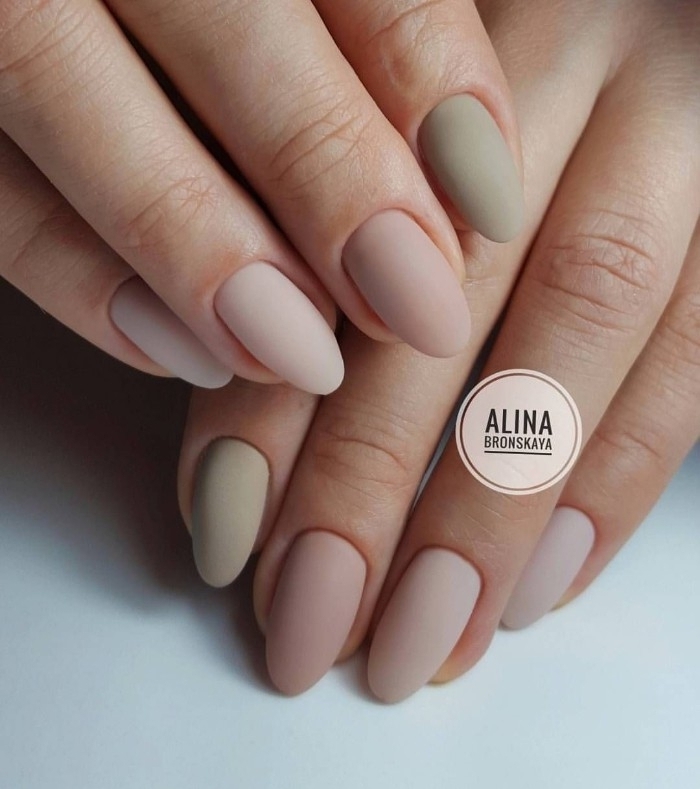 shades pf pastel pink, and grey matte nail polish, on the oval manicure of two hands