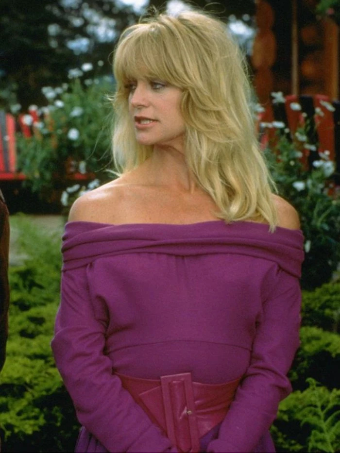 purple off-the-shoulder dress, with a wide purple leather belt, 80's fashion pictures, worn by goldie hawn, with blonde wavy hair and bangs