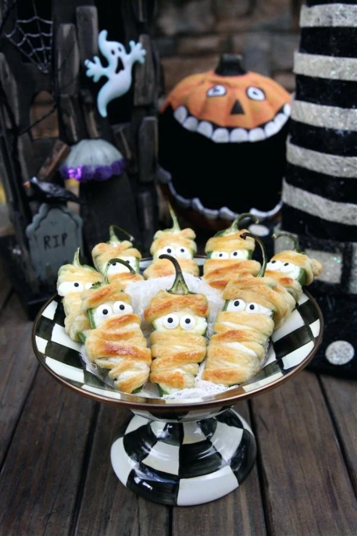jalapeno poppers for halloween, wrapped in grilled cheese, and decorated with little eyes, resembling mummies or ghosts