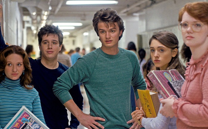 steve harrington played by joe keery, dressed in a greenish-blue sweater, with a wavy quiff hairdo, 80s costumes