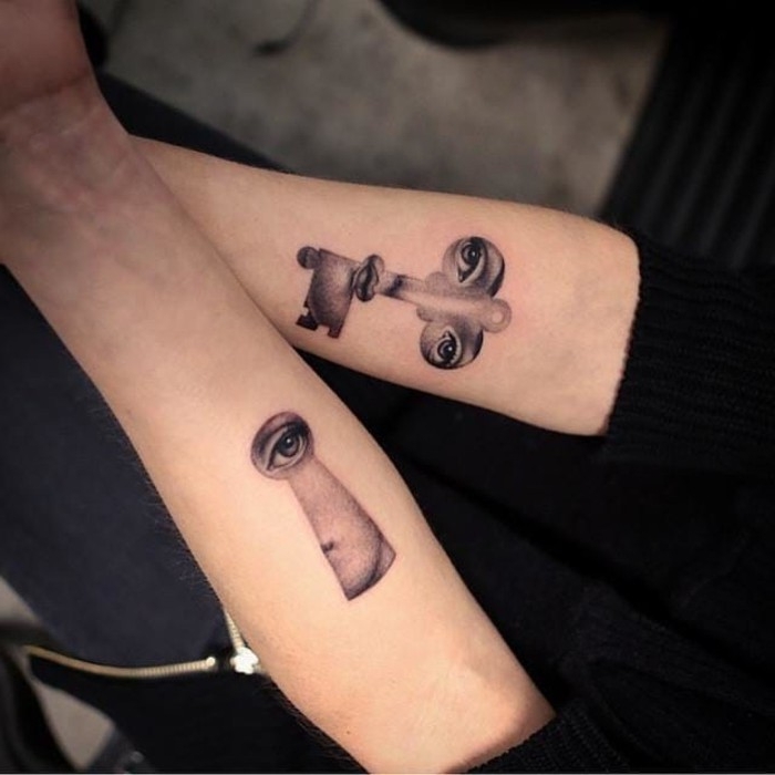 parts of a woman's face, depicted on a key, and inside a keyhole, matching tattoos, done in grey on the lower part, of two arms 