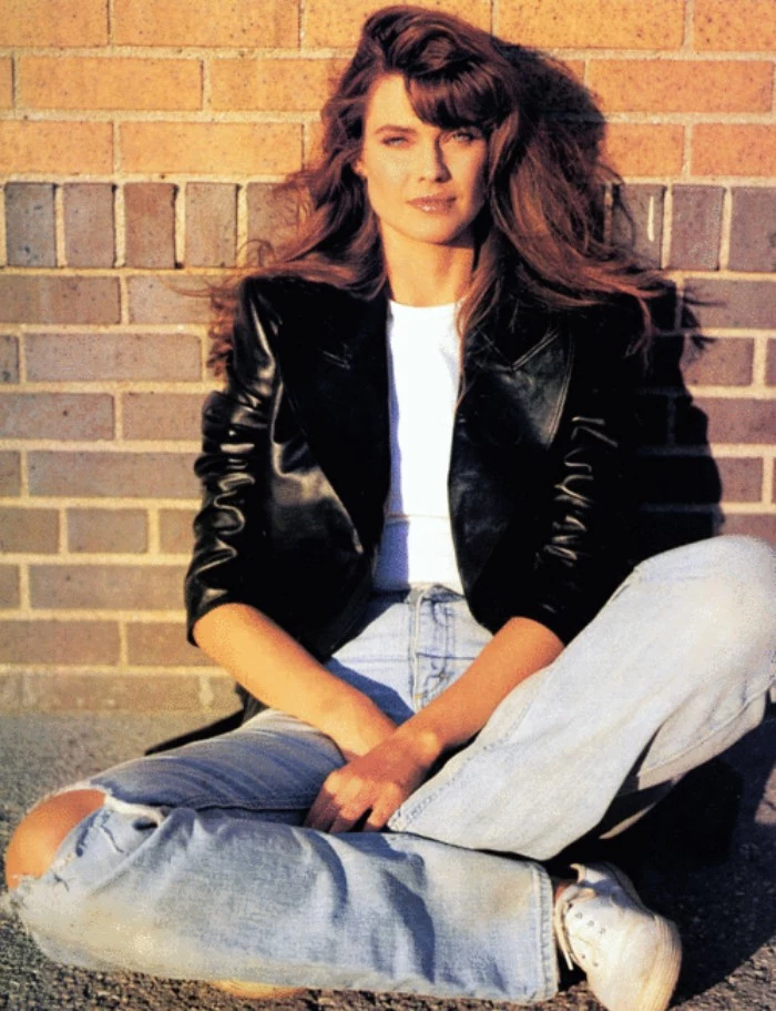 80's fashion pictures, young woman with long, wavy brunette hair, dressed in sidtressed high waisted jeans, a white t-shirt, and a black leather jacket