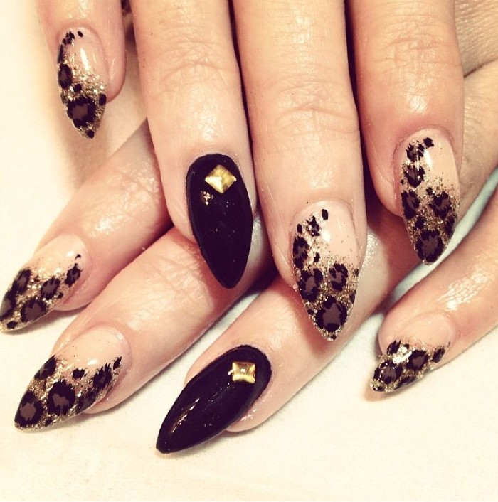 animal print effect nails, in nude and black, decorated with gold rinestones and glitter, short stiletto nails