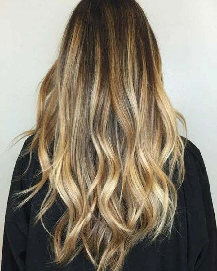golden blonde bayalage, on long dark brunette hair, with loose curls, seen from the back
