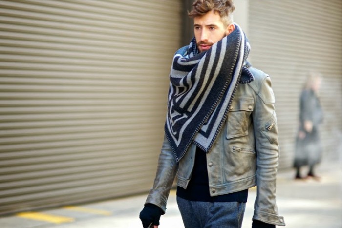 moustached man in a grey biker jaket, walking down the street, with black gloves, and an oversized scarf, in two sahdes of grey, ways to wear a blanket scarf for guys