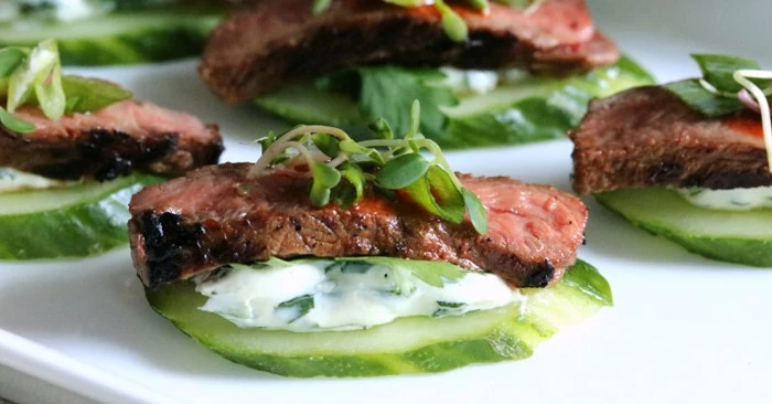 beef pieces medium rare, on top of cucumber slices, with a yoghut spread, hor dourves garnished with watercress