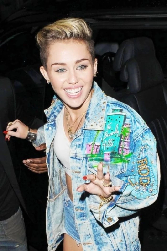applique details and patches, on an oversized denim jacket, worn by miley cyrus