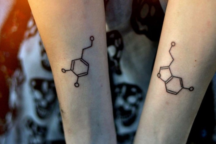 chemistry-inspired tattoos, featuring two molecules, done with black ink, on two slim arms