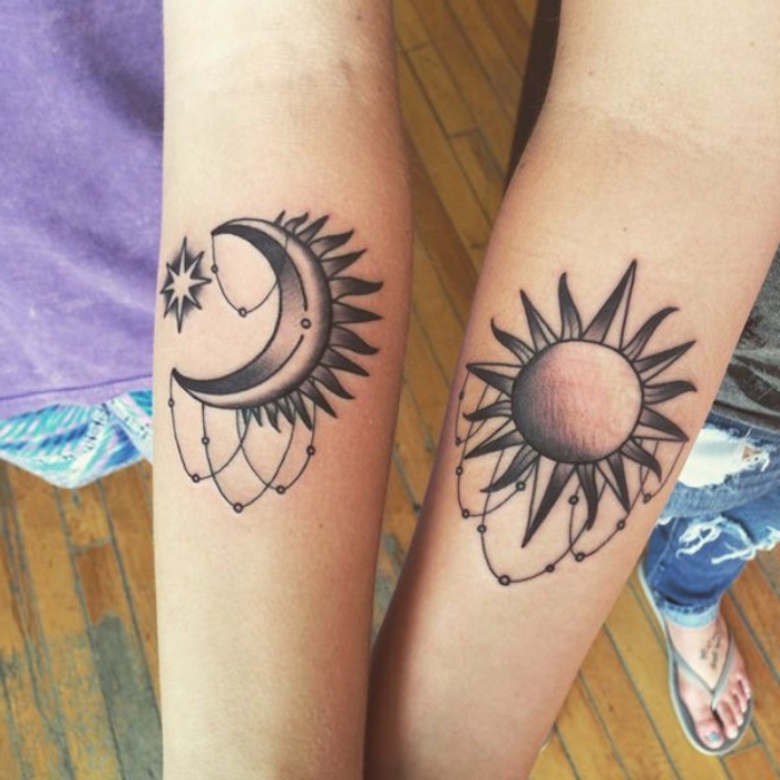 moon with a star, and a sun, tattooed on the lower part of two slim, and pa...