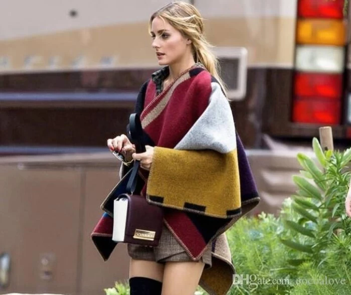 block colored oversized scarf, worn like a cardigan, by a slim young blonde woman, in beige woolen shorts