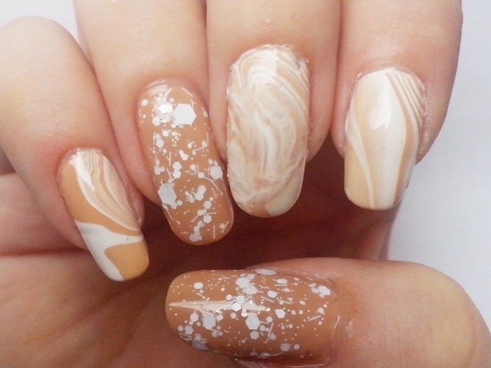 splatters and swirls of white nail polish, on long oval nails, in nude beige, nude nail designs