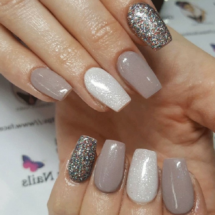 pearlescent nail polish, in silver and beige, on eight coffin shaped nails, nude nails with glitter in different colors