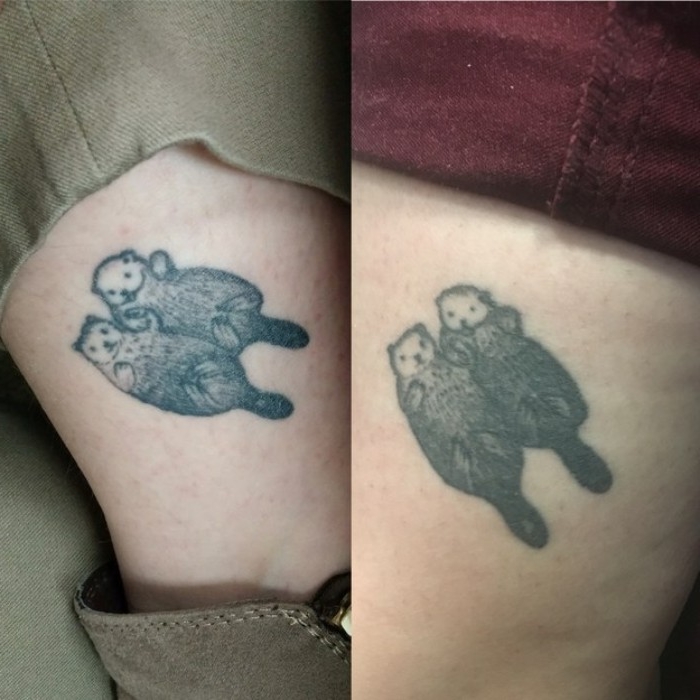 identical tattoos of otters, lying on their backs, and holding hands, matching tattoos for couples in love, done with grey ink