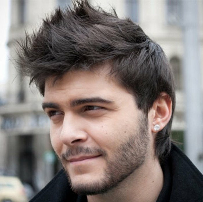 thick black hair, styled in faux hawk, trendy haircuts for men, worn by a pale young man, with short mustache and beard