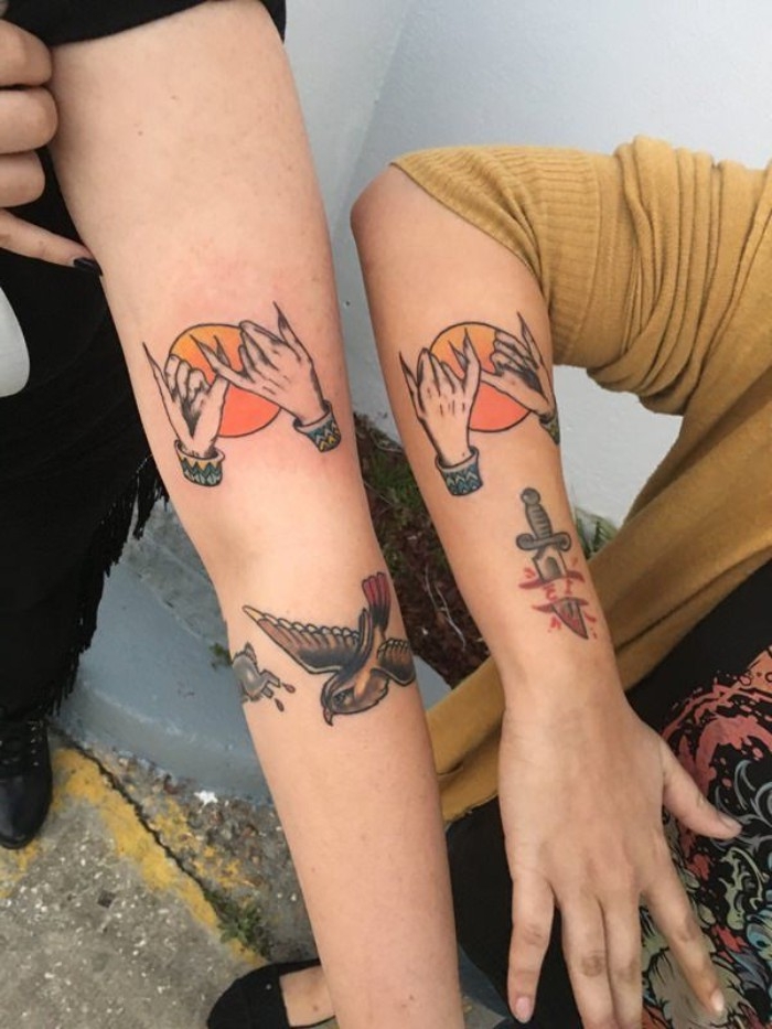 another version of the pinky promise tattoos, done in color, matching bestfriend tattoos, on the arms of two people, with other colorful tattoos