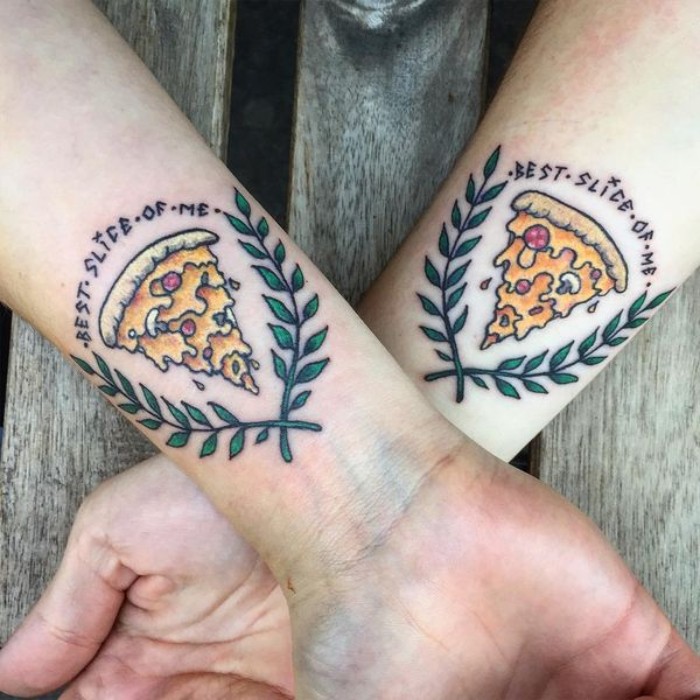 laurel leaves surrounding a pizza slice, accompanied by the inscription best slice of me, matching bestfriend tattoos, in full collor, on the wrists of two crossed arms