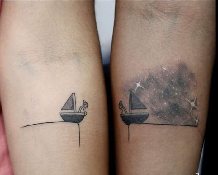 stick figures in two sailing boats, tattooed under the nooks of the elbows of two arms, matching friend tattoos, one has a starry sky in the background