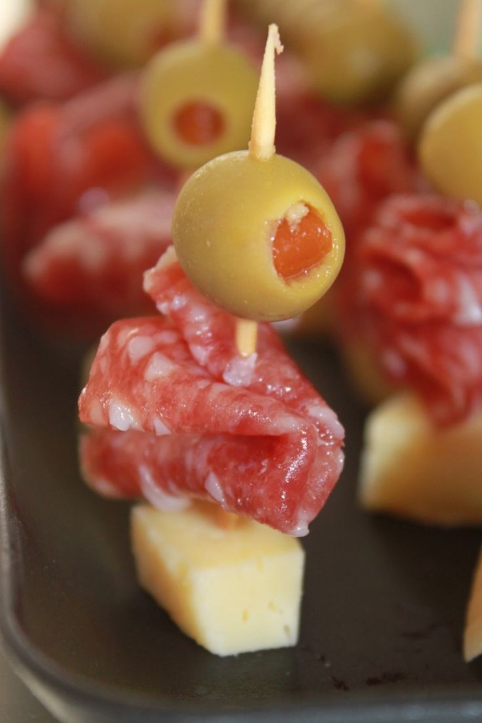 pitted green olive, stuffed with marinated red pepper, and skewered with a piece of salami, and some cheese