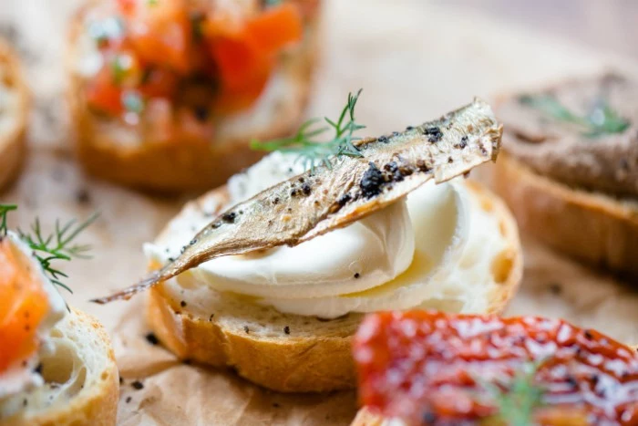 sardine dried and smoked, topping a piece of toast, smeared with creamy white spread, hor d oeuvres ideas for new year's eve