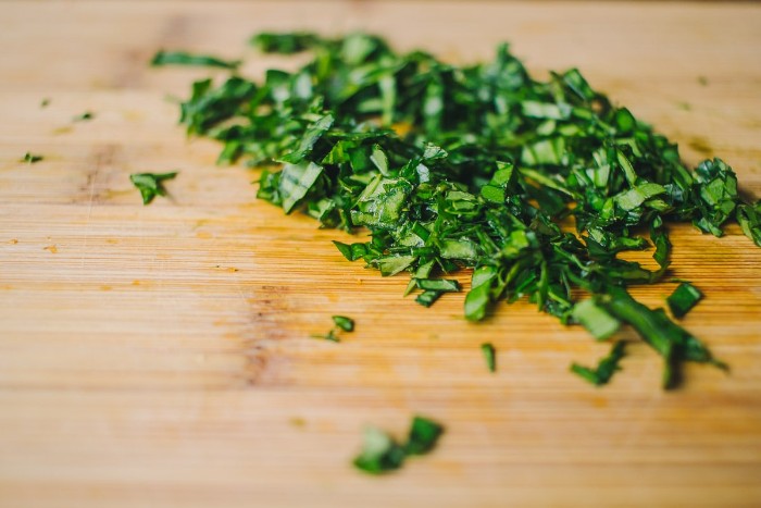 chopped fresh basil, on a wooden cutting board, seen in extreme close up, horderves step by step