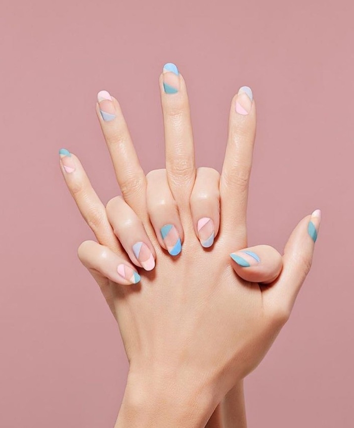 candy colored striped manicure, in pastel pink and turquoise, on the nude, oval shaped nails, of two hands