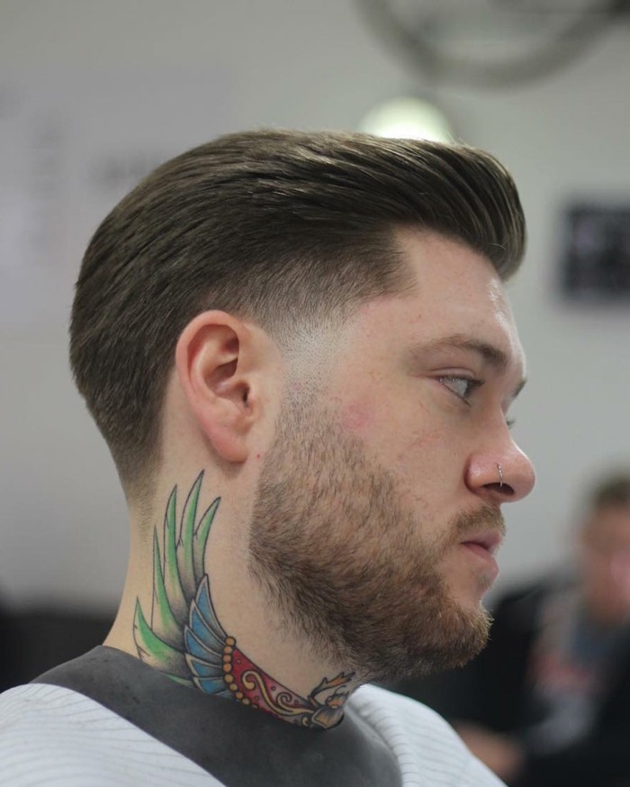 nose ring and colorful tattoo, worn by a young man, with short hair, featuring a pompadour like detail, trendy haircuts for men, worn with short beard and mustache