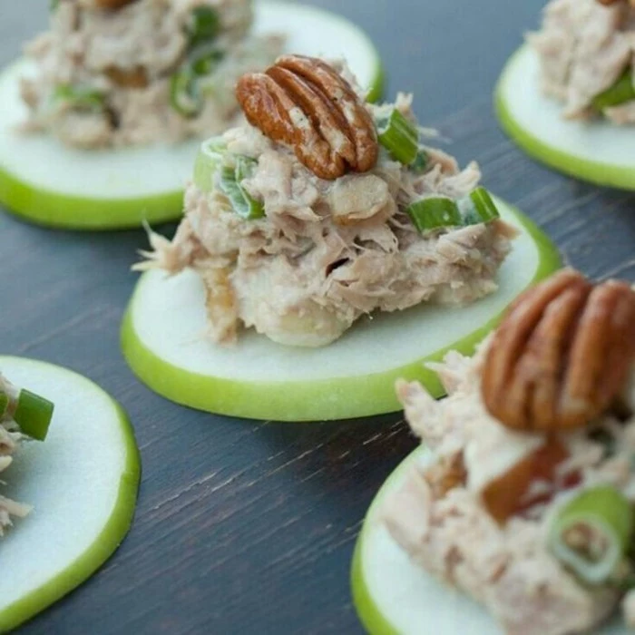 pecan nuts topping appetizers, consisting of apple slices, covered with tuna mayo, and green chopped onions
