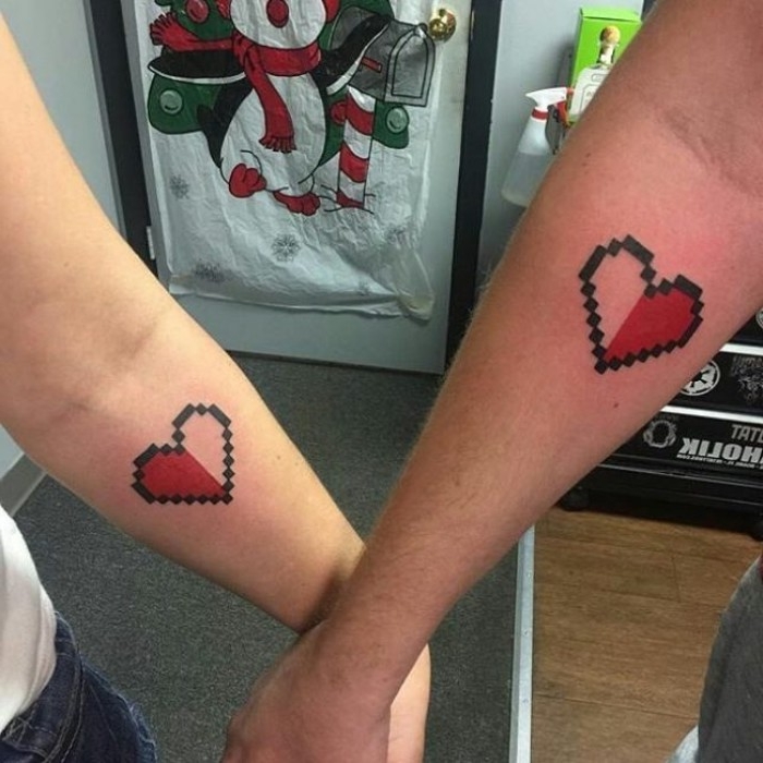 heart shapes inspired from video games, half filled with red ink, and with a pixelated effect, his and hers tattoos, done bellow the crook of the elbow 