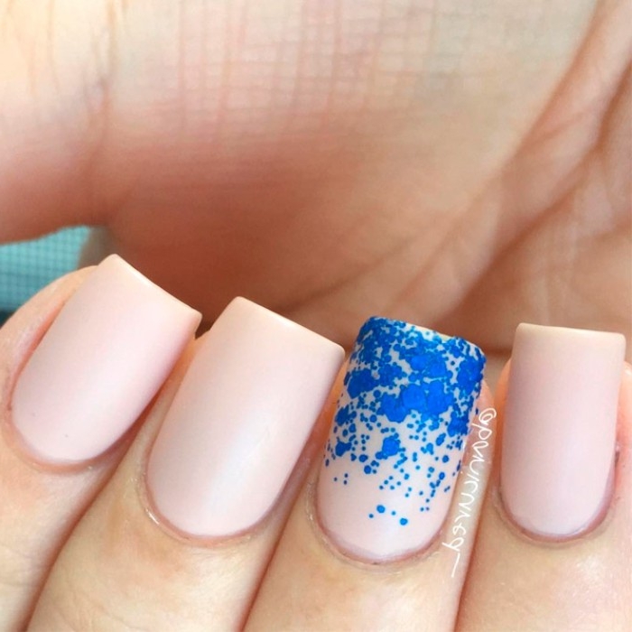 bright blue dots, decorating four nude matte nails, seen in extreme close up, short square manicure