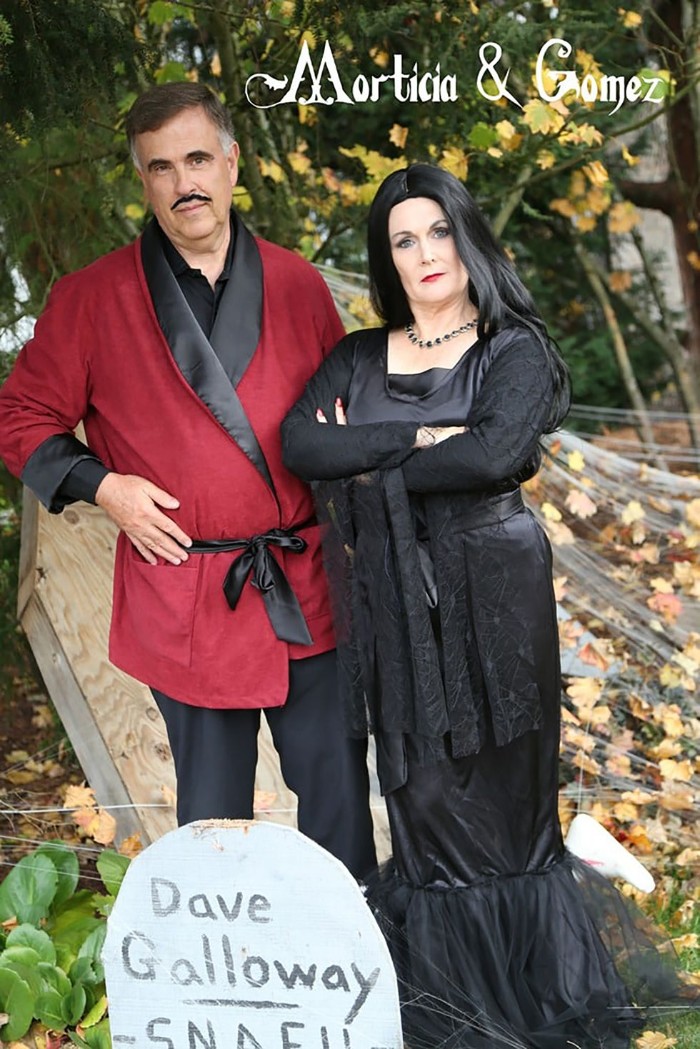 gomez and morticia addams, duo halloween costumes, worn by elderly man and woman, black and red bathrobe and faux mustache, black maxi dress and wig