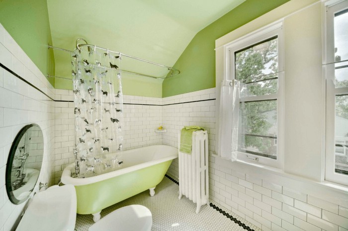 subway tiles in white, with a black detail, covering the bigger part, of three pale green walls, bathroom color schemes, retro-style bathtub, two windows and a green ceiling