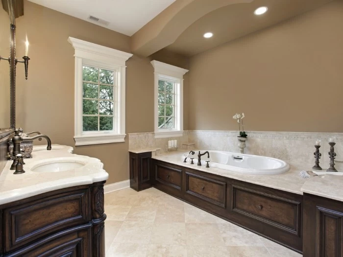 mocha colored bathroom, with dark brown wooden furniture, and pale beige countertops, bathroom color schemes, vintage style inbuilt bathtub and sinks