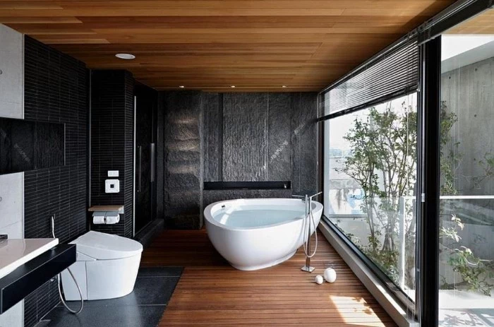 bathroom remodel pictures, room with wooden floor and ceiling, featuring dark grey mosaic tles on the walls, and a white bathtub
