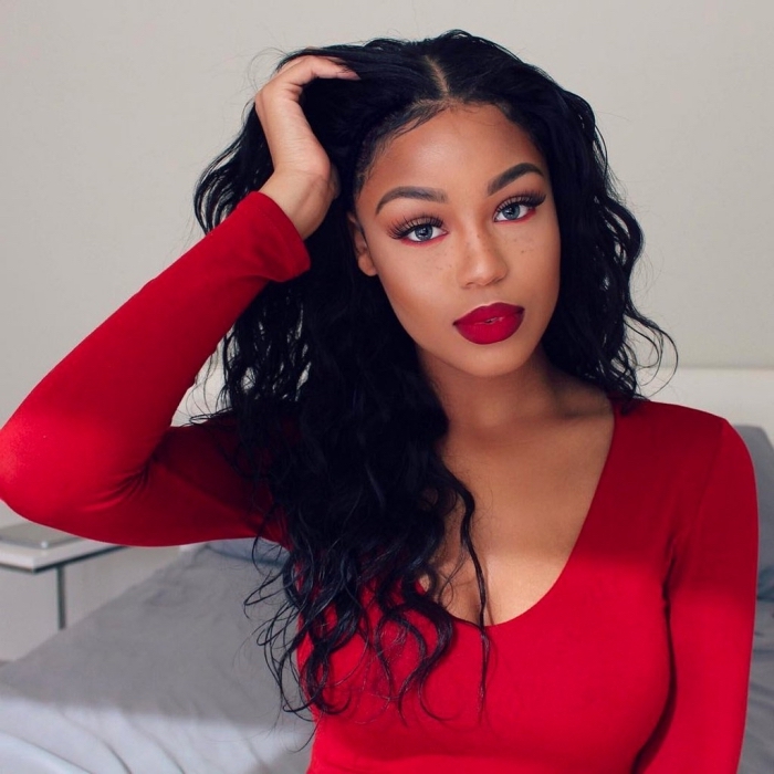faux eye lashes, and red eyeliner worn under the eyes, by a young black woman, with red lipstick, eye makeup for red lips, black curly hair, and a red top