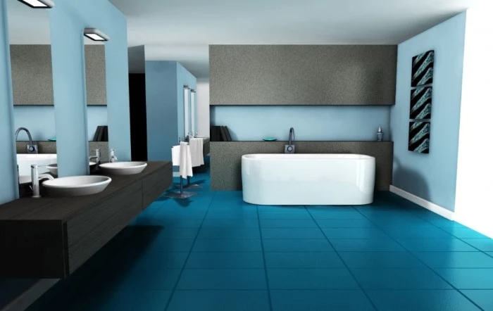 spacious bathroom with blue tiled floor, pale blue walls with grey details, a white bathtub, two tall mirrors, and two white sinks, on a black counter