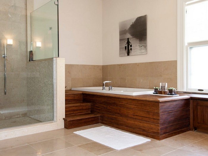 shower cabin near an elevated bath. surrounded by wooden panels, pale beige tiles, bathroom remodel pictures, window and a framed photo