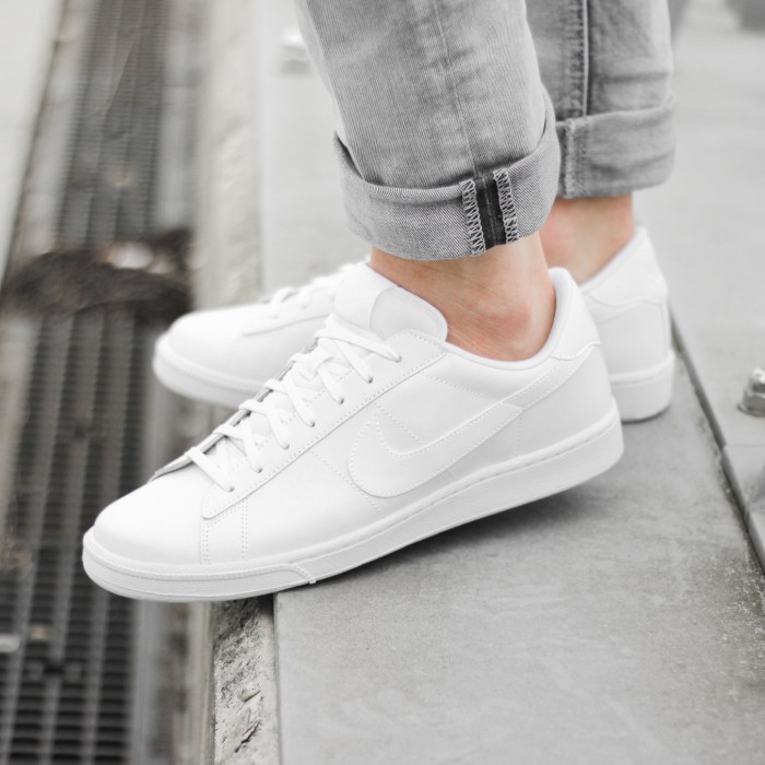 plain white nike lace up sneakers, worn by a person, dressed in pale grey jeans, what is a capsule wardrobe, basic everyday clothes and shoes