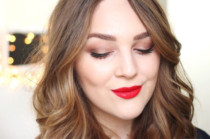 mocha brown christmas eyeshadow, worn with bright red lipstick, by a pale brunette woman, with caramel brown wavy hair