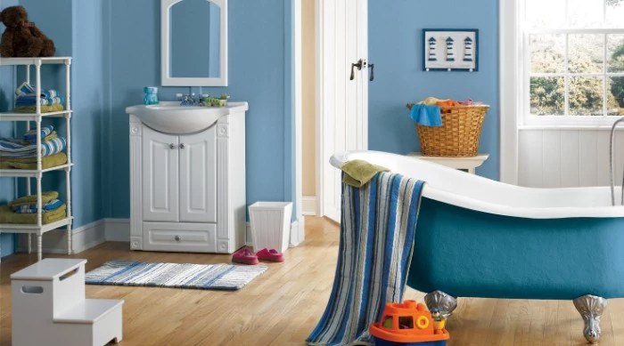 bathroom paint colors, pale blue walls, in a room with light beige laminate floor, containing an antique, blue and white clawfoot tub