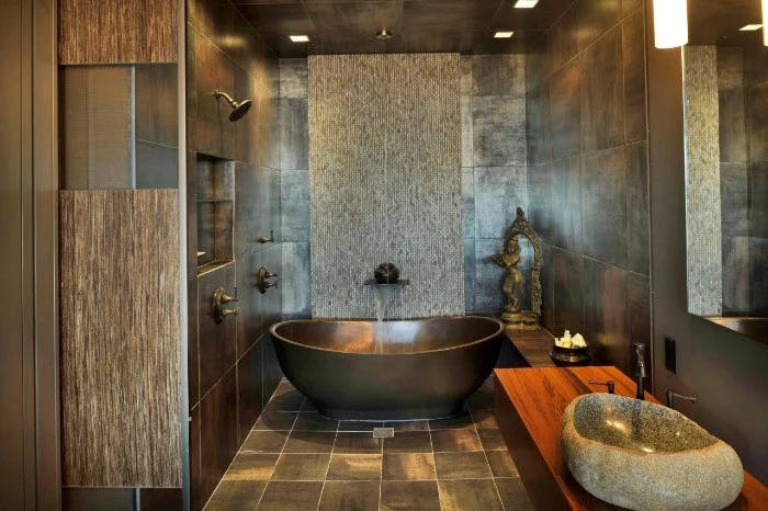 brown and dark grey walls and floor, inside a room, containing a dark grey bathtub, master bath remodel, sink made from a piece of stone