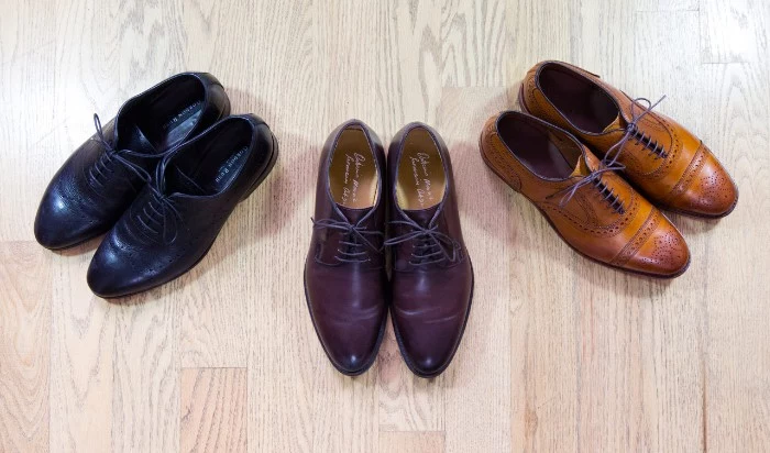 smart shoes for men, brogues in black, dark and light brown, capsule wardrobe men, on a laminate floor