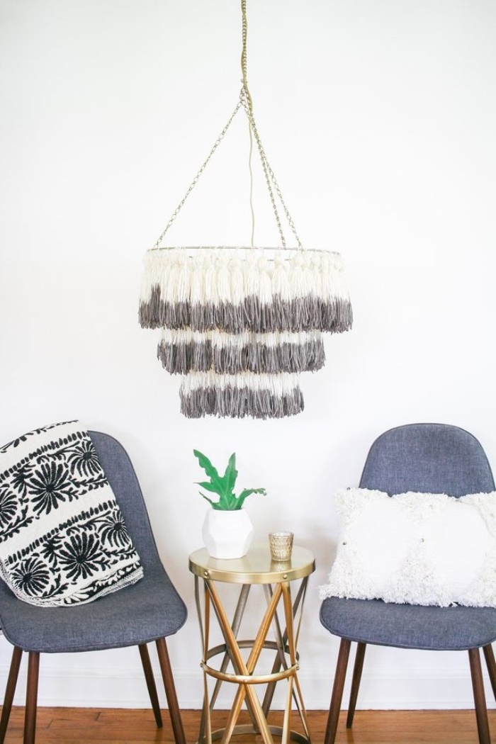 two dark grey modern chairs, and a small metallic coffee table, near a DIY chandelier, decorated with handmade tassels, room makeover, in a few easy steps