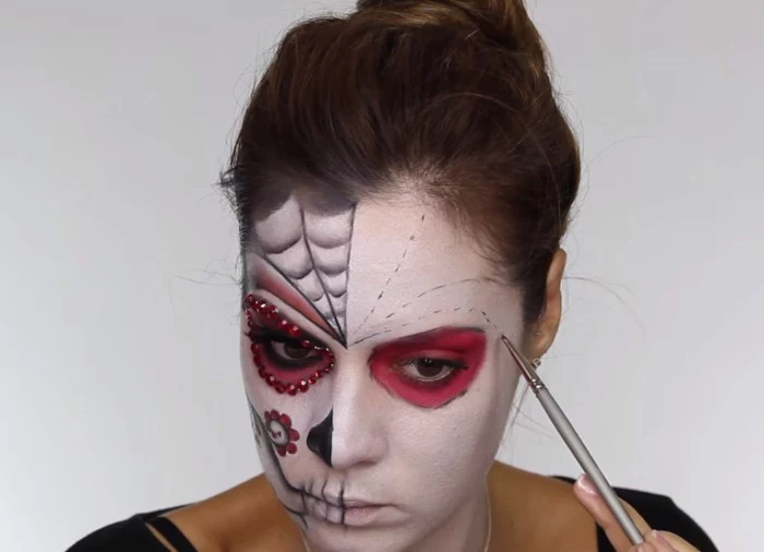 spider web details, and floral motifs, painted on the face of a young woman, covered in white paint, skeleton face paint, sugar skull style