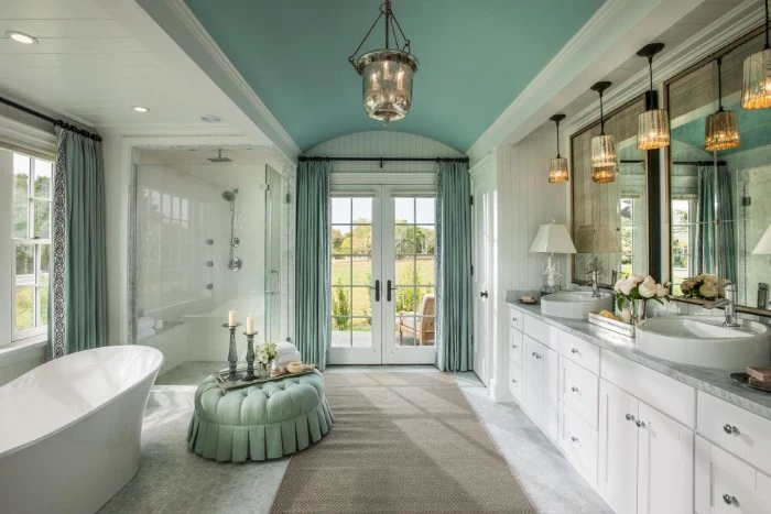 spacious classic bathroom, in duck's egg blue and white, with a beige rug, master bathroom ideas, tub and shower cabin, several different lamps