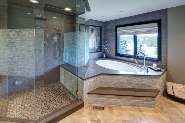 roomy glass shower cabin, near an elevated oval bathtub, master bathroom remodel, light beige laminate floor, window and mosaic tiles