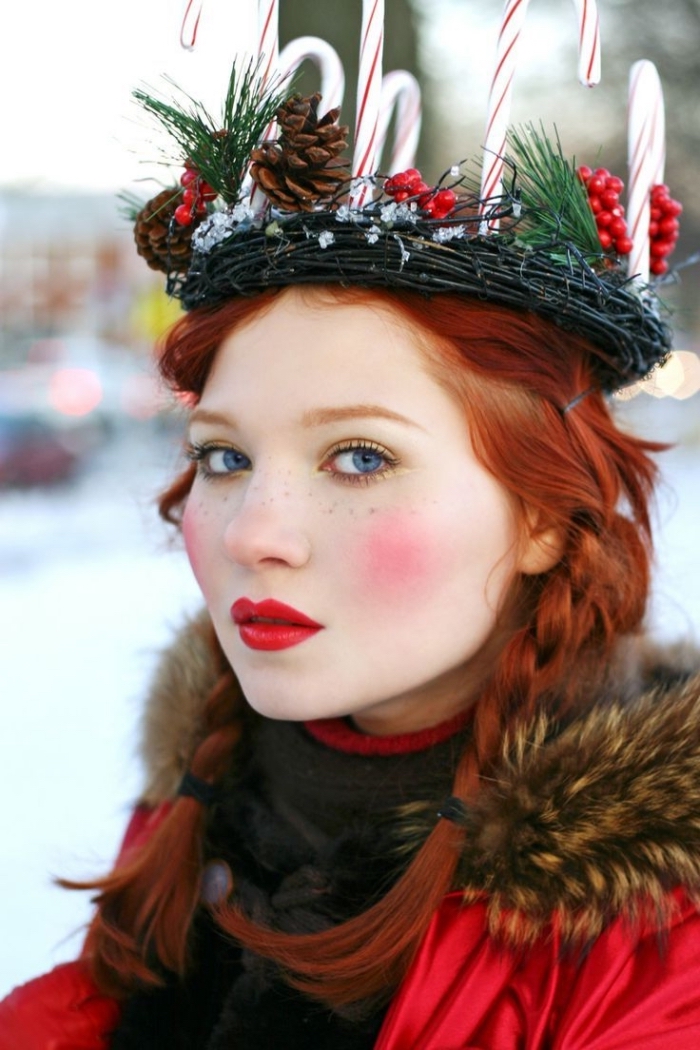 doll-like makeup, with bright red lipstick, and intense pink blush, christmas makeup ideas, worn by a red-haired young woman, with a christmas wreath on her head