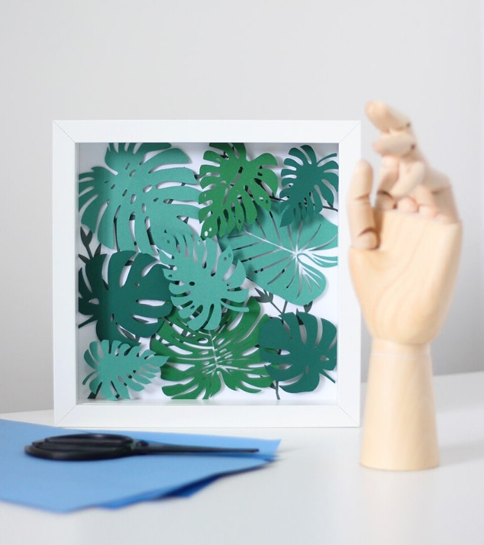 3D paper artwork, consisting of many different palm leaves, in various shades of green, how to decorate a bedroom wall, in a white frame